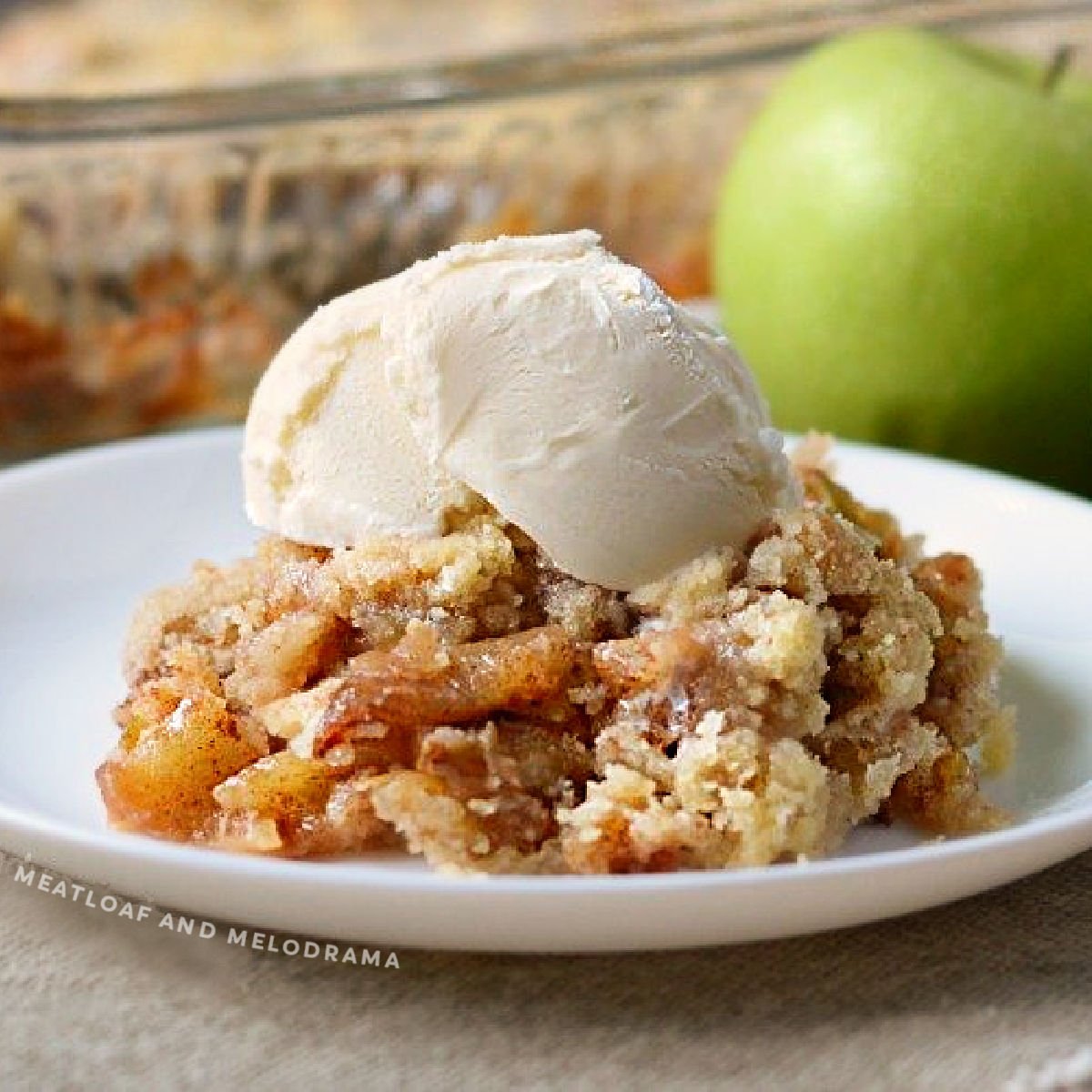 apple crisp without oats on a plate with vanilla ice cream on top