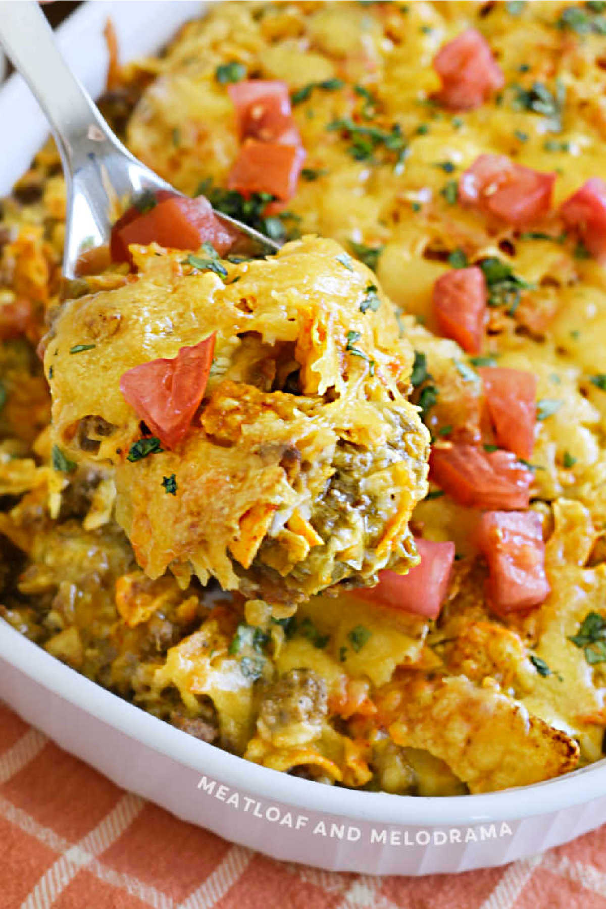 Dorito Casserole with ground beef and tomatoes on a serving spoon