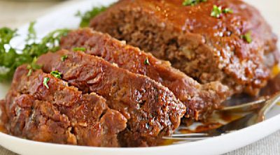 meatloaf with tomato sauce and brown sugar glaze on white platter