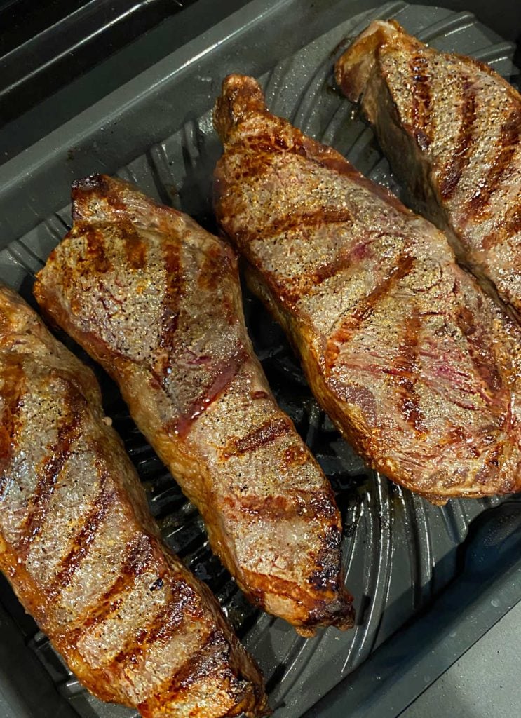 grilled new york strip steaks with grill marks on indoor grill