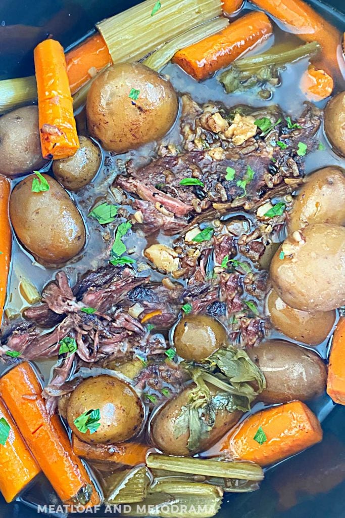 slow cooker pot roast in beef broth with potatoes and carrots and celery