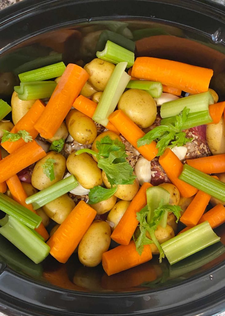 pot roast with carrots potatoes and celery in slow cooker