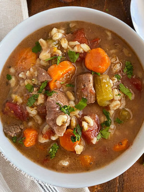instant pot beef barley soup with pearl barley, carrots, celery and tomatoes in bowl