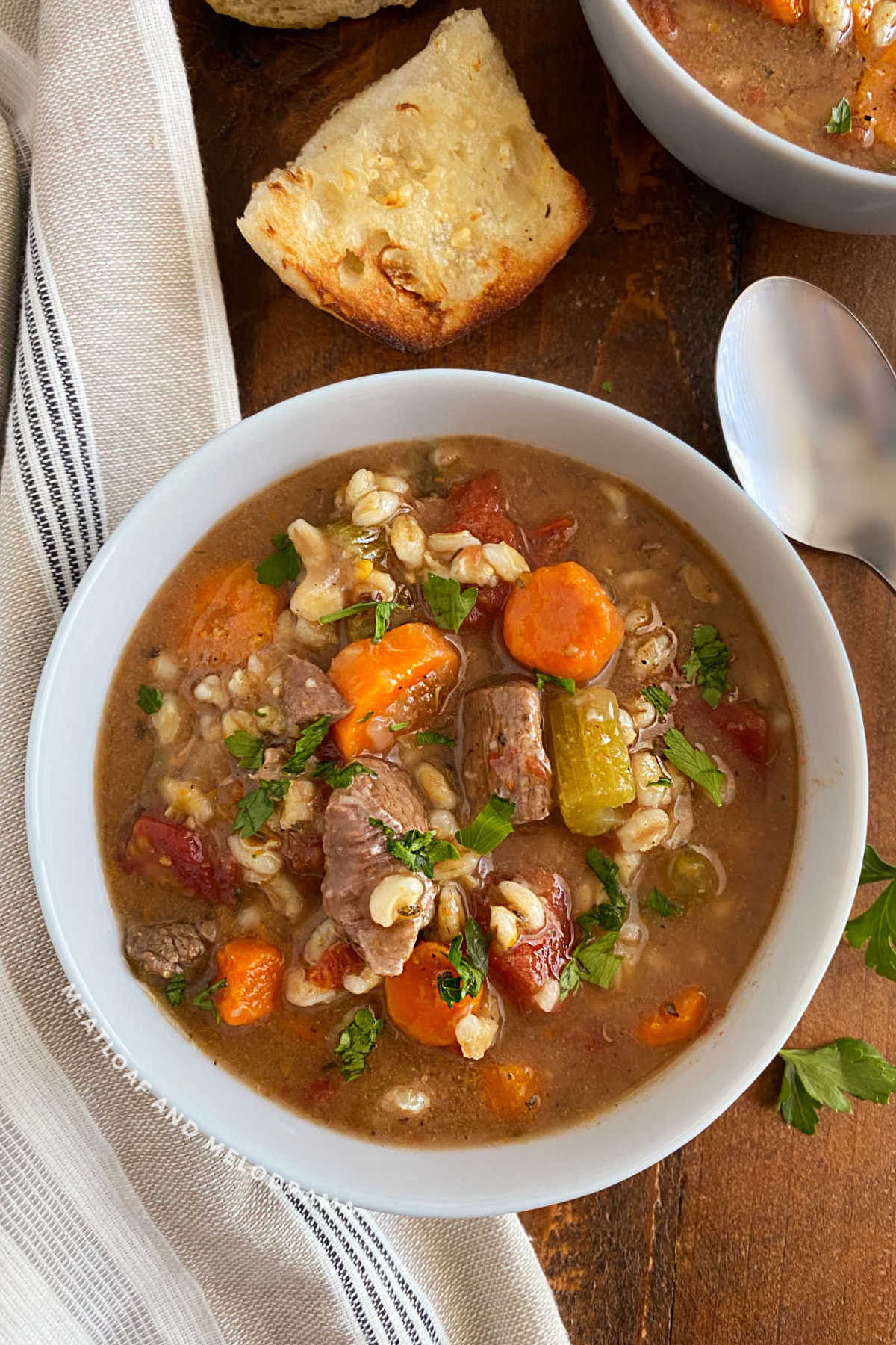 bowl of grandma's instant pot beef barley soup with crusty bread on the table