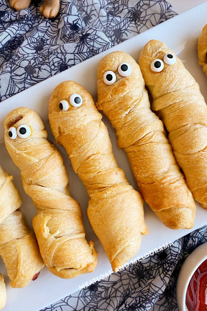 halloween mummy dogs with candy eyes on a platter