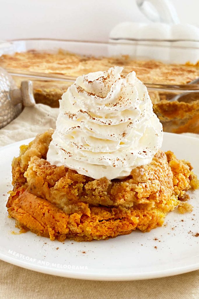 pumpkin dump cake with crunch topping and whipped cream on a plate