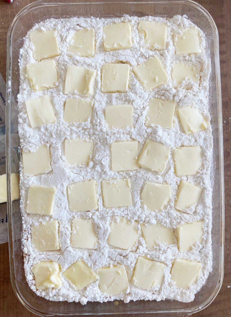 slices of butter on cake mix in pan