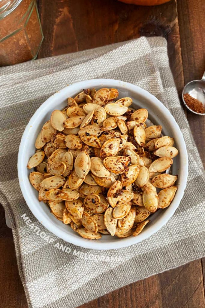 seasoned roasted pumpkin seeds in white bowl on the table