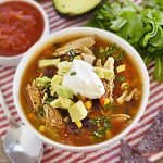 bowl of instant pot chicken taco soup with black beans and avocado on the table