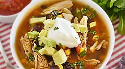 bowl of instant pot chicken taco soup with black beans and avocado on the table