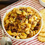 instant pot chili mac in a white bowl with crackers on the table