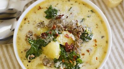instant pot zuppa toscana with kale in white bowl with bacon and pepper flakes