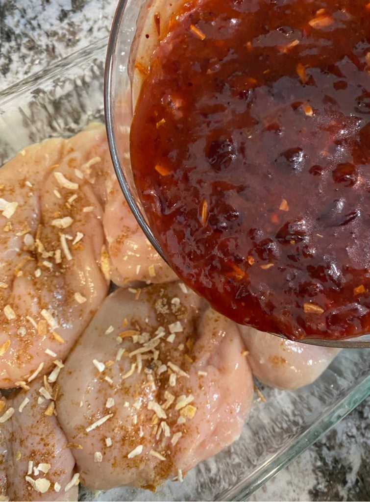 pour cranberry sauce over chicken breasts in baking pan