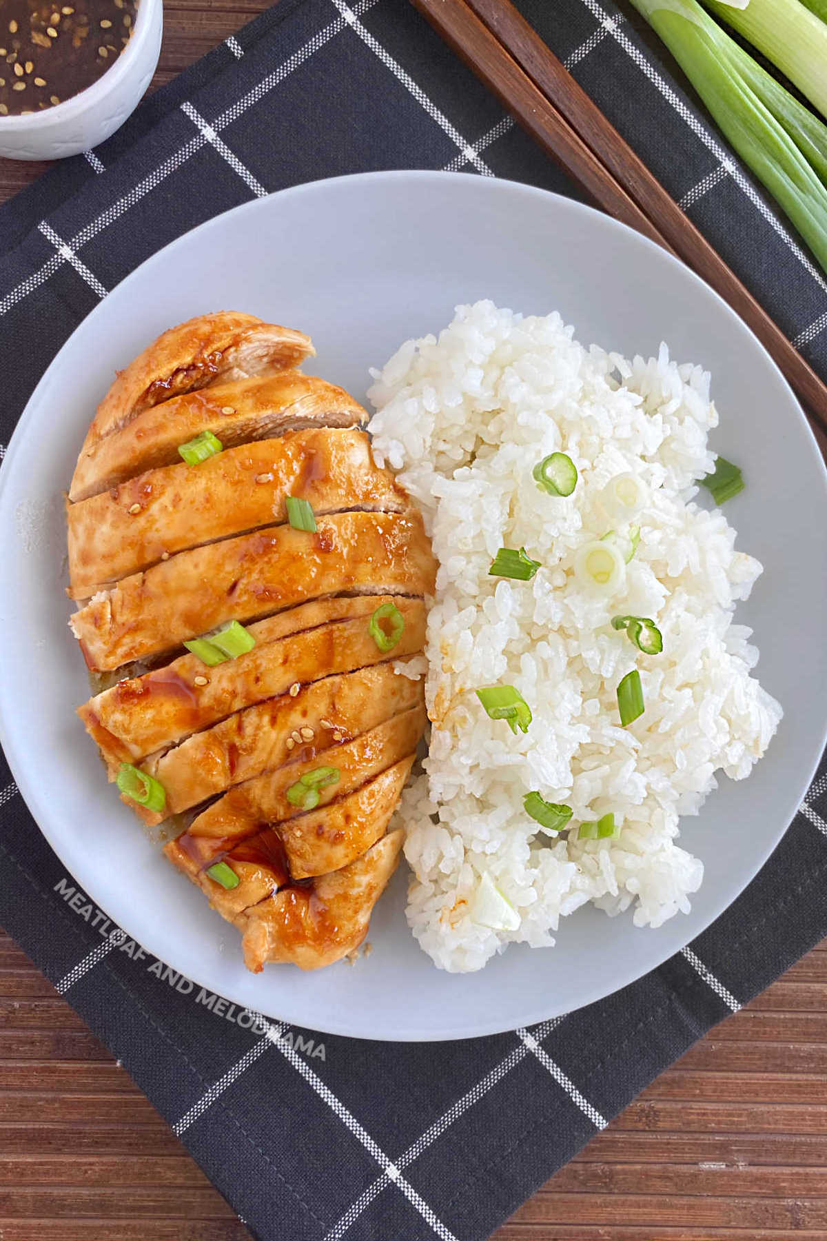 baked teriyaki chicken breast with green onions and white rice on a plate