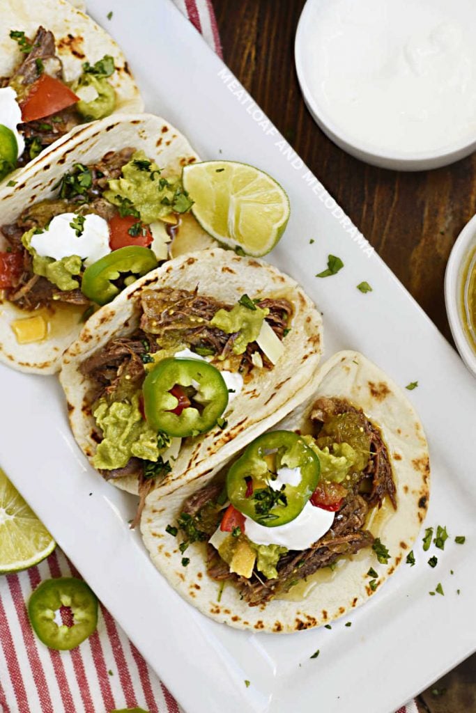 instant pot shredded beef tacos with sour cream on platter