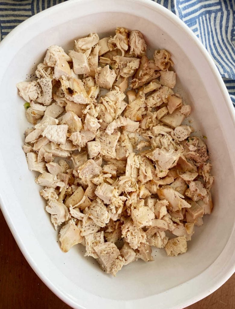 cooked cut up leftover turkey in a white baking dish