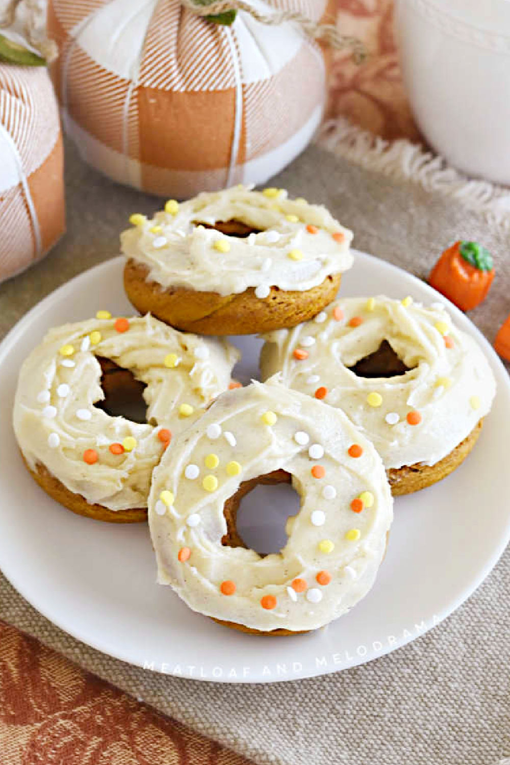 baked pumpkin cake mix donuts with cream cheese frosting and sprinkles on platter