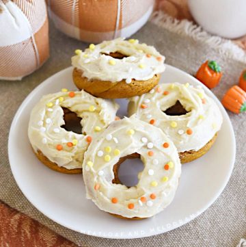 pumpkin spice cake mix donuts with cream cheese frosting on platter