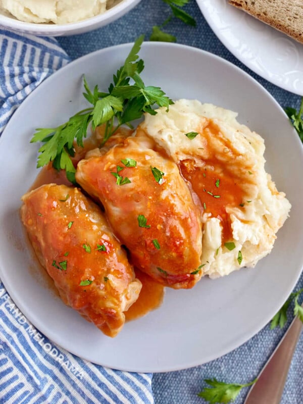 2 cabbage rolls (slovak halupki) in tomato soup sauce with mashed potatoes on plate