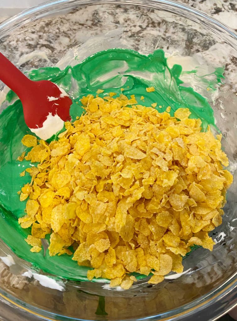 stir cornflakes into marshmallows and food coloring