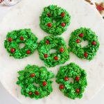 Christmas cornflake wreath cookies with red candies on cake stand