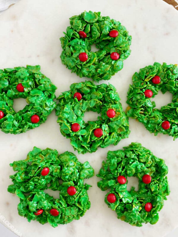 Christmas cornflake wreath cookies with red candies on cake stand