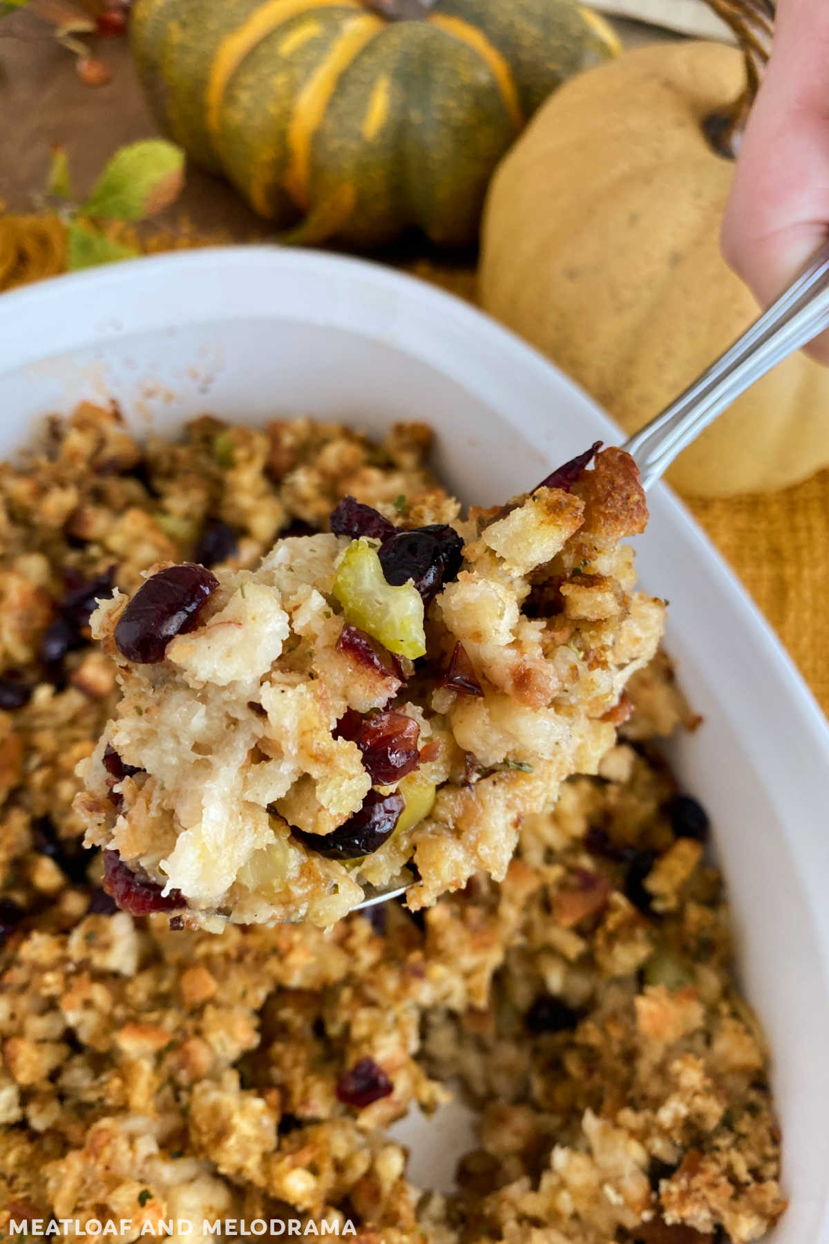 cranberry apple sausage stuffing on a serving spoon on Thanksgiving table