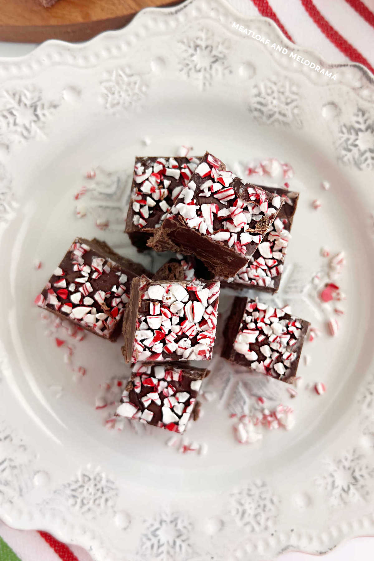 dark chocolate peppermint fudge with crushed peppermint candies on top on a plate