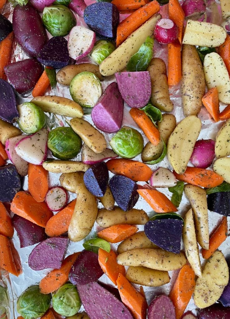 raw root veggies and brussels sprouts on sheet pan