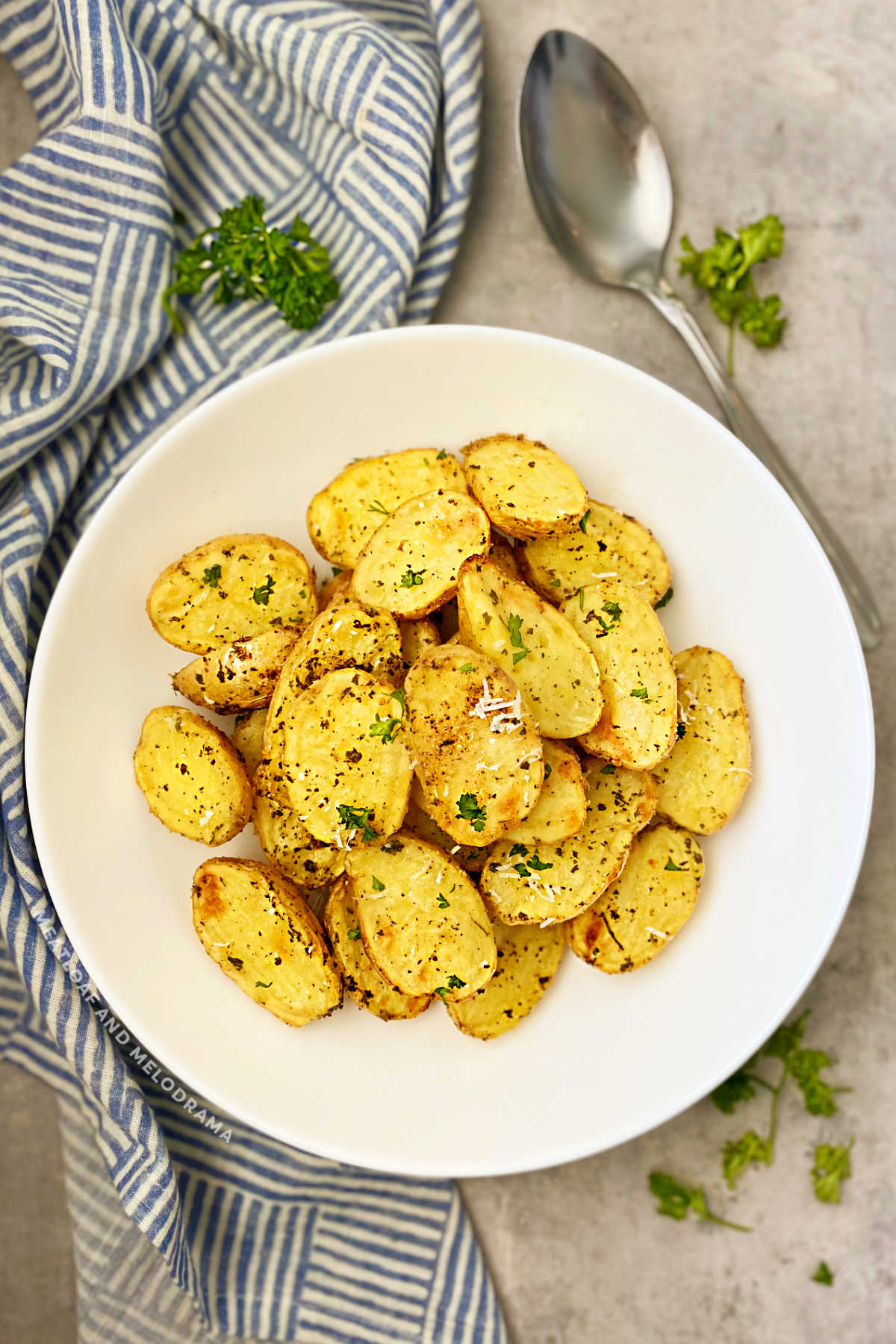 roasted baby dutch yellow potatoes with parsley and Parmesan in white bowl