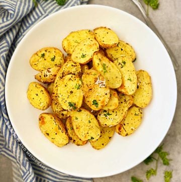 roasted baby dutch potatoes with fresh parsley and Parmesan in white bowl