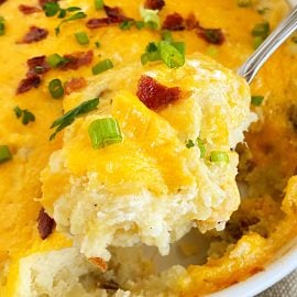 twice baked potatoes casserole with cheddar, bacon and green onions on a serving spoon