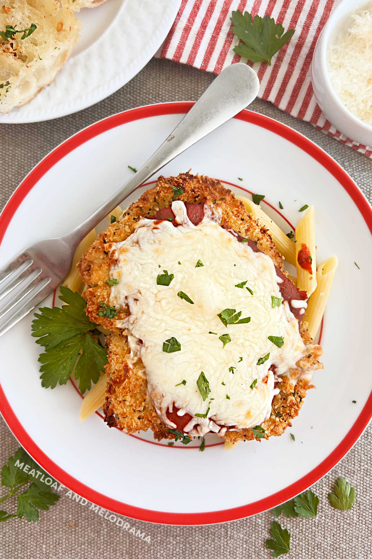 panko coated baked chicken Parmesan with melted mozzarella cheese over penne pasta