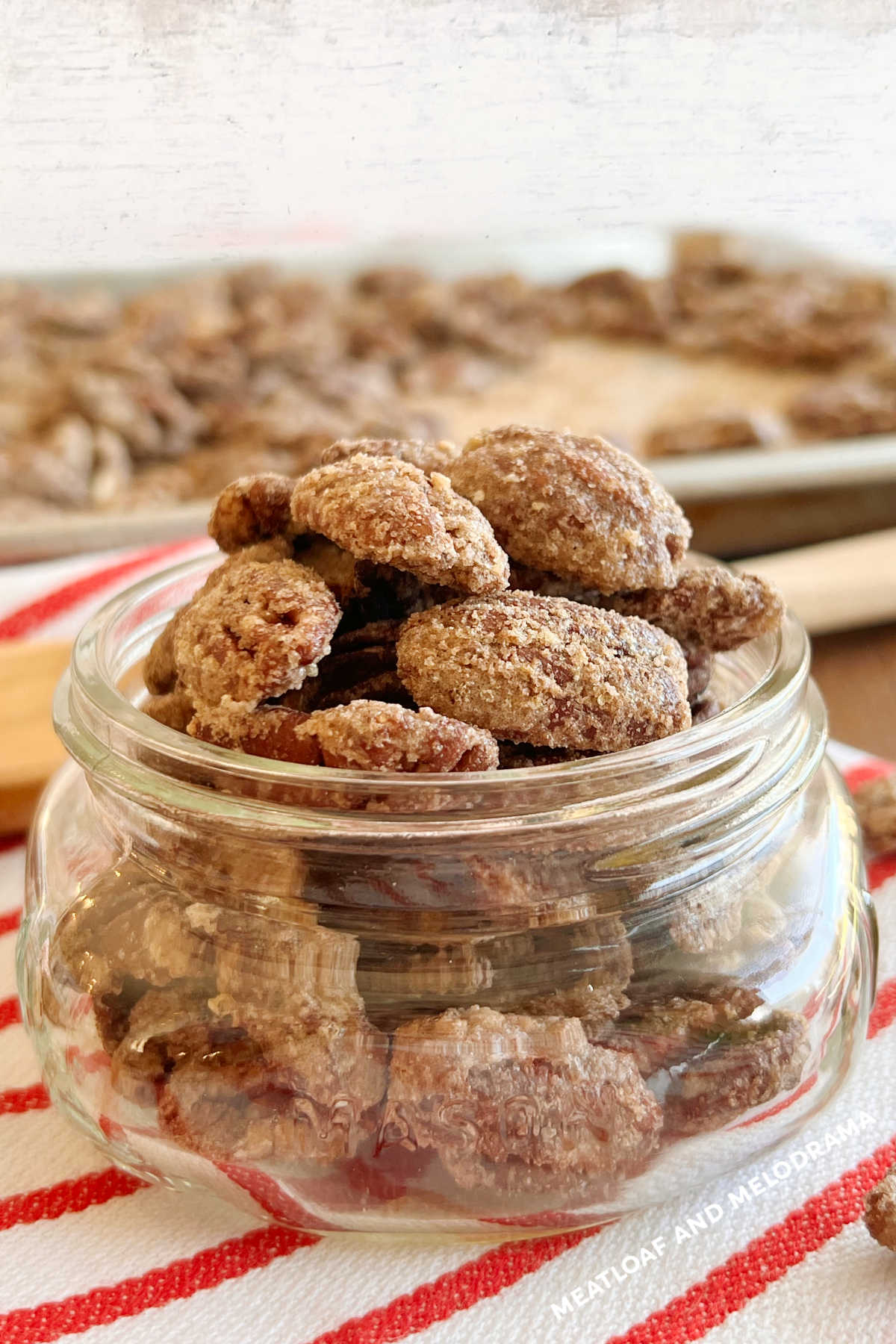 roasted candied pecans in mason jar on red and white towel