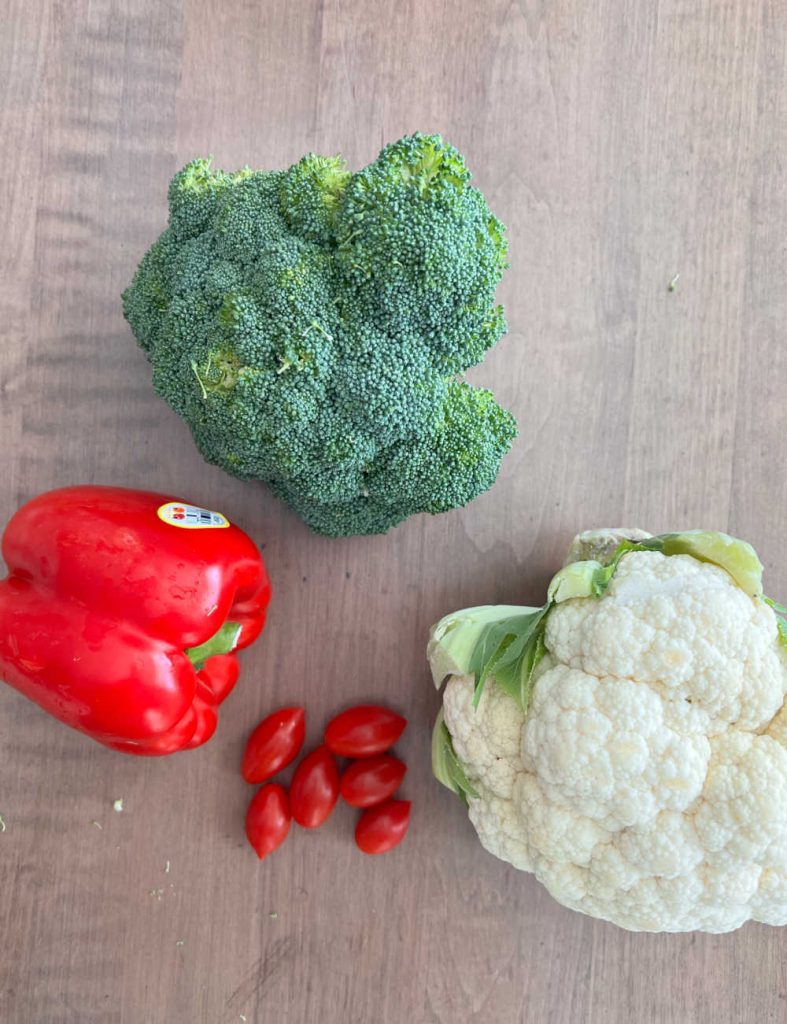 broccoli, bell pepper, grape tomatoes and cauliflower on table