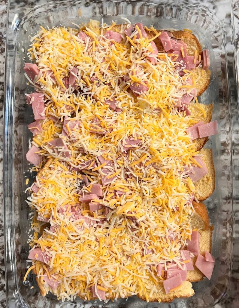 layer bread, ham slices and shredded cheese in baking dish