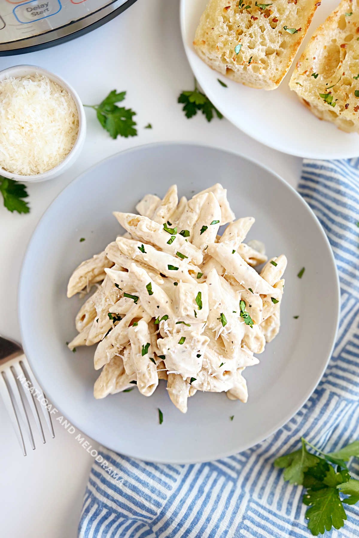 instant pot chicken alfredo pasta with garlic bread and Parmesan on the table