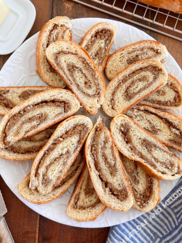 slices of grandma's nut roll with swirls walnut filling on a white platter