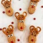 nutter butter reindeer cookies with pretzel antlers on marble cake stand