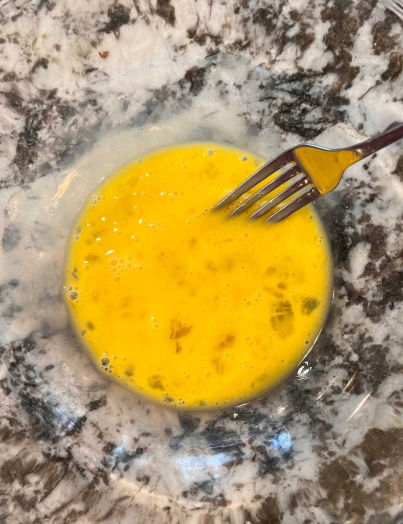 beat eggs with fork in mixing bowl