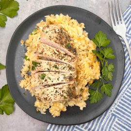 grandma's one pan no peek chicken and rice on a black plate with parsley