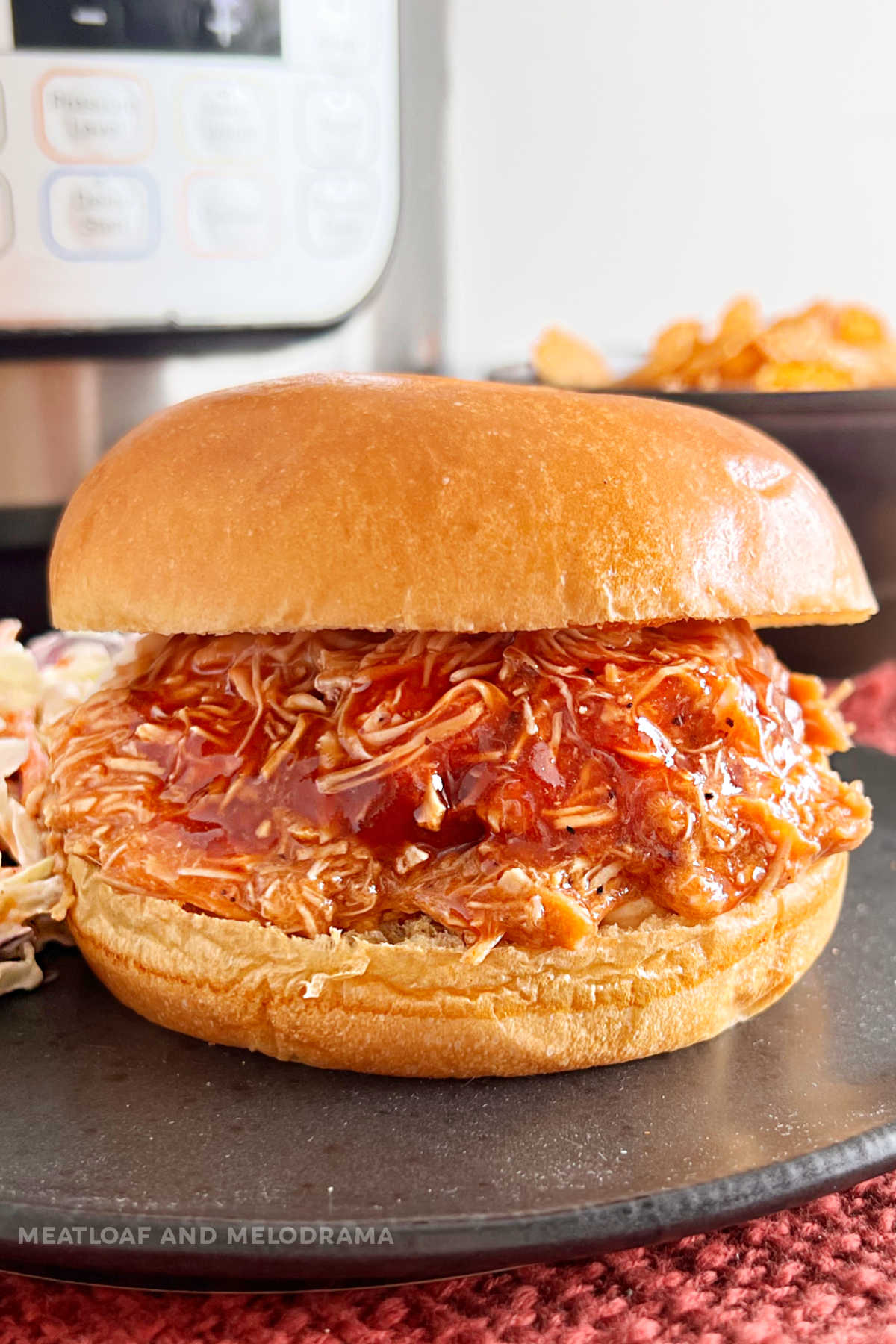 instant pot pulled bbq chicken sandwich on brioche bun on the table