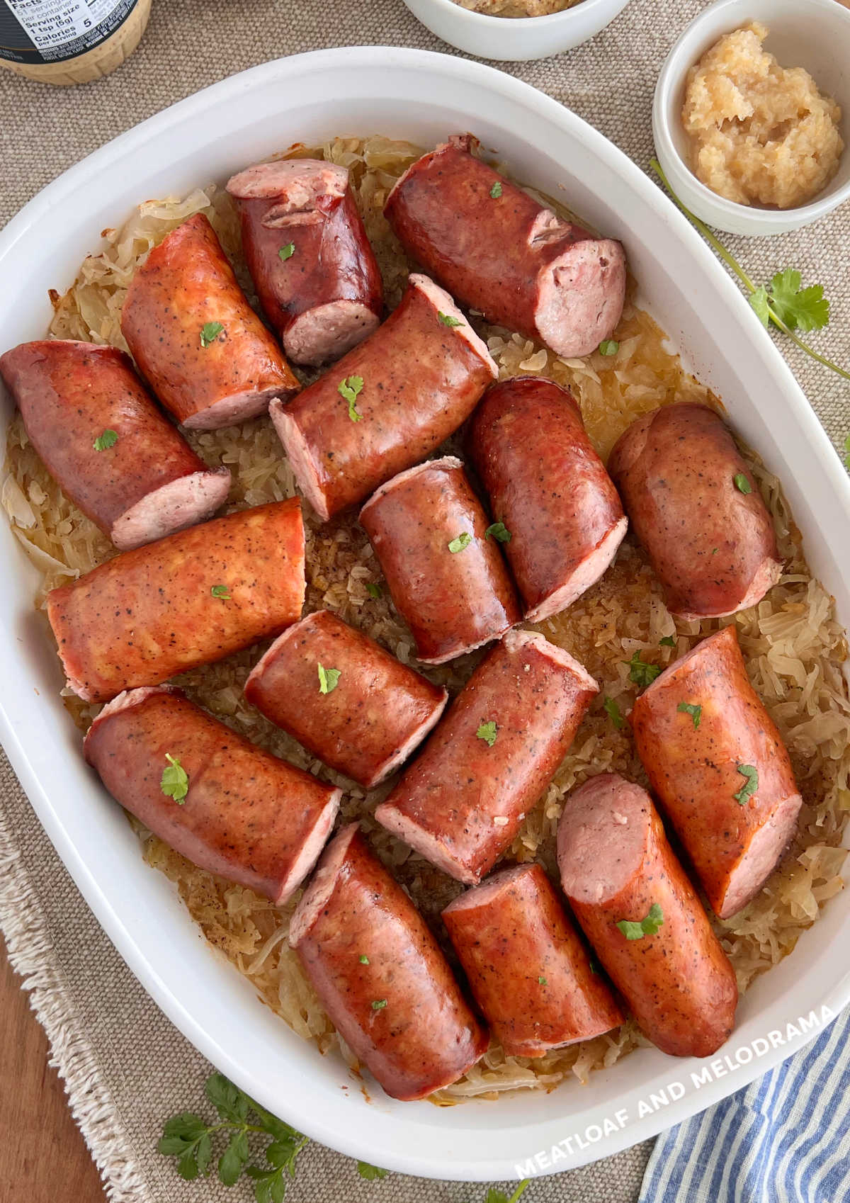 polska kielbasa and sauerkraut in casserole dish with side of horseradish on the table