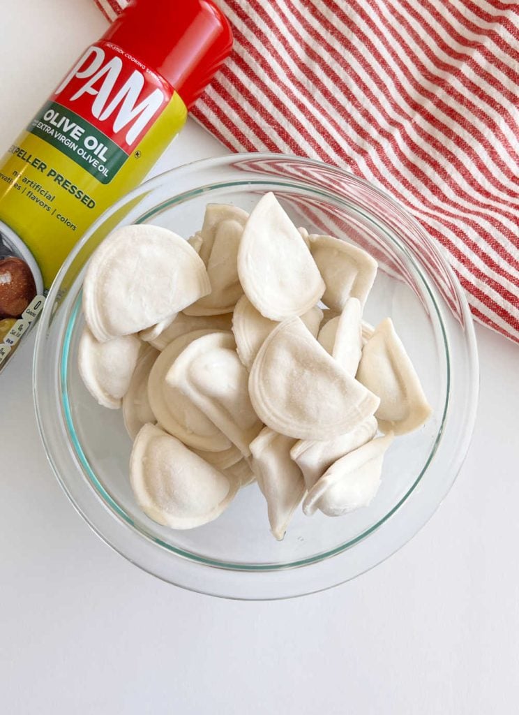 olive oil spray and Mrs T's frozen pierogies in a bowl
