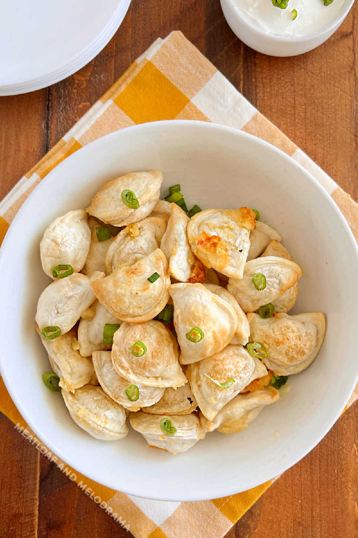 air fryer pierogies with onions in a white bowl on the table