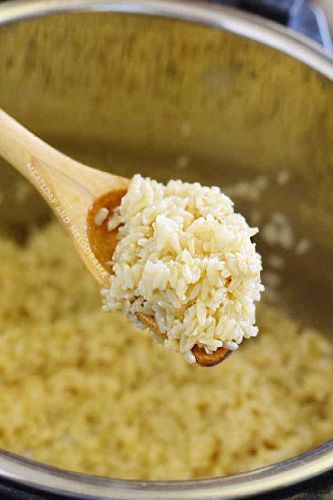 perfectly cooked brown rice on a wooden spoon over the instant pot