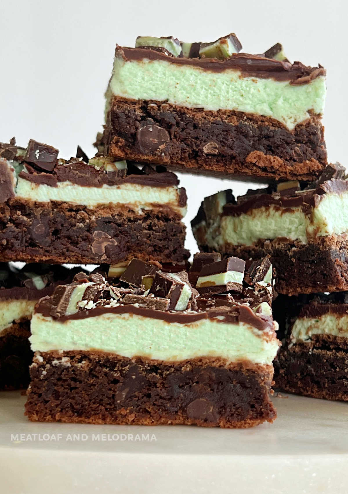 mint chocolate brownies with mint frosting and chocolate ganache and andes mints stackedd