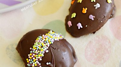 homemade peanut butter eggs covered in melted chocolate with Easter sprinkles on top