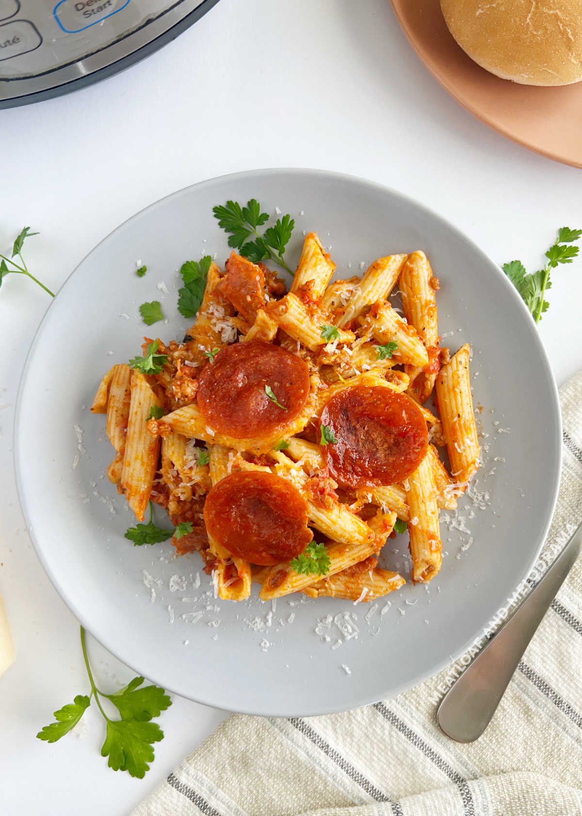 plate of instant pot pizza pasta with penne and pepperoni slices on the table