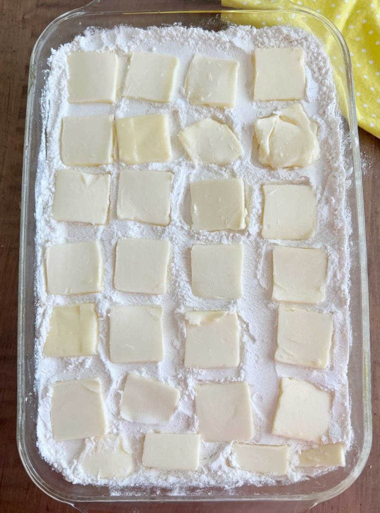 pats of butter on top of dry cake mix in baking dish